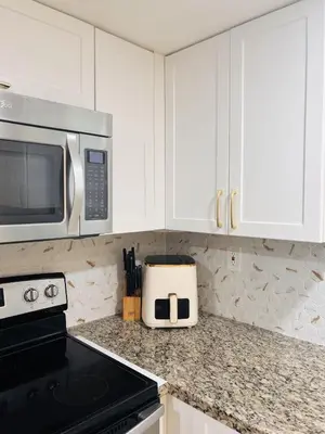 a kitchen with white cabinets and a microwave at Le Frontenac in Sunny Isles unit 402 STR-03003 in Sunny Isles Beach