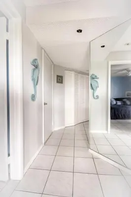 a hallway with a mirror with seahorses on the wall at Le Frontenac 404 STR-02799 in Sunny Isles Beach