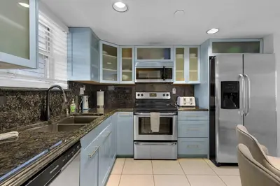 a kitchen with blue cabinets and stainless steel appliances at Le Frontenac 413 STR-03005 in Sunny Isles Beach