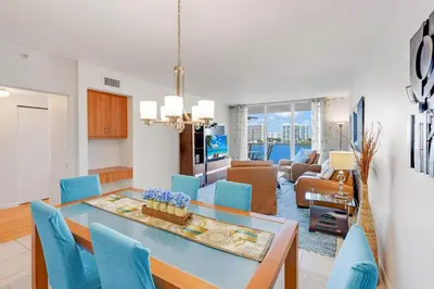 a dining room and living room with a table and chairs at Le Marina Bay 1004 STR-02738 in Sunny Isles Beach