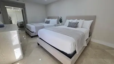 a bedroom with two beds and a mirror at Penthouse Condo - Oceanfront - Miami Beach - sleeps 8 in Miami Beach