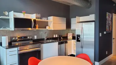a kitchen with white appliances and red chairs at Brickell Condo, with FREE parking in Miami