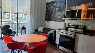 a kitchen with a table and red chairs in a room at Brickell Condo, with FREE parking in Miami