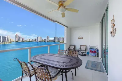 a balcony with a table and chairs and the water at Le Marina Bay 1106 STR-03006 in Sunny Isles Beach