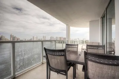 a dining room with a table and chairs on a balcony at Le Marina Bay 1109 STR-01972 in Sunny Isles Beach