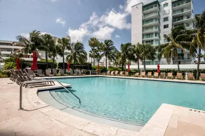 a swimming pool with chairs and a building at Le Marina Bay 1109 STR-01972 in Sunny Isles Beach