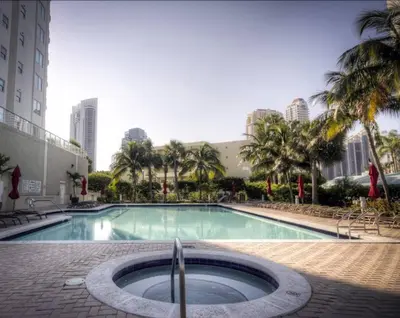 a large swimming pool with palm trees and buildings at Le Marina Bay 310 STR-01478 in Sunny Isles Beach
