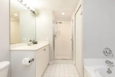 a white bathroom with a shower and a sink at Le Marina Bay 403 STR-01408 in Sunny Isles Beach