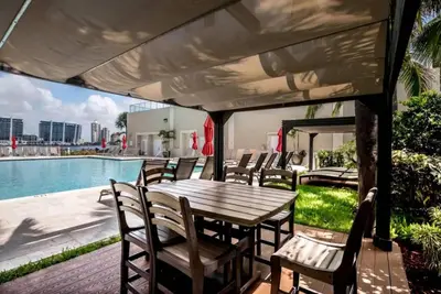 a table and chairs on a patio next to a pool at Le Marina Bay 403 STR-01408 in Sunny Isles Beach