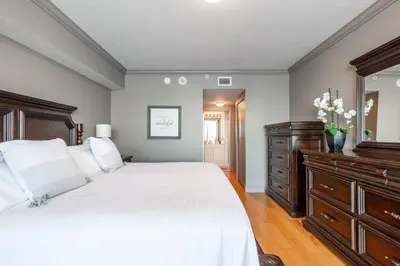 a bedroom with a bed and a dresser and a mirror at Le Marina Bay 409 STR -02439 in Sunny Isles Beach