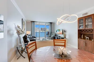 a dining room with a table and chairs and a living room at Le Marina Bay 505 STR-02744 in Sunny Isles Beach
