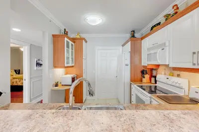 a kitchen with white cabinets and a sink at Le Marina Bay 505 STR-02744 in Sunny Isles Beach