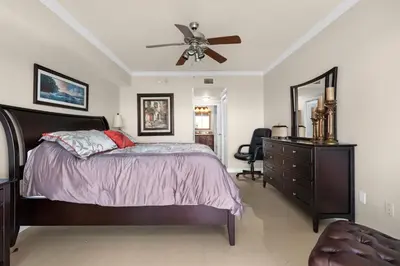 a bedroom with a bed with a ceiling fan and a dresser at Le Marina Bay 603 STR-02736 in Sunny Isles Beach
