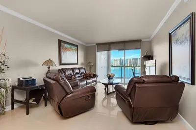 a living room with two leather couches and a table at Le Marina Bay 603 STR-02736 in Sunny Isles Beach