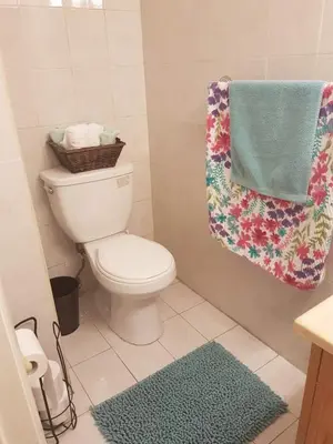 a bathroom with a toilet with a towel and a rug at Le Marbella 303 STR-02828 in Sunny Isles Beach