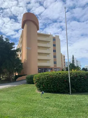 a building with a bird in the grass in front of it at Le Marbella 303 STR-02828 in Sunny Isles Beach