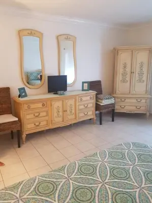 a room with a dresser with two mirrors and a tv at Le Marbella 303 STR-02828 in Sunny Isles Beach
