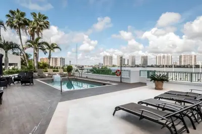 a patio with chairs and a swimming pool on a building at Le Montcalm 303 STR-01919 in Sunny Isles Beach