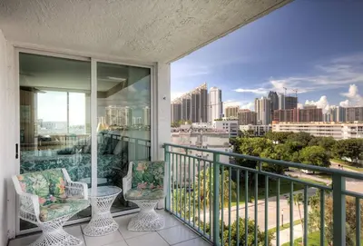 a balcony with two chairs and a view of the city at Le Montcalm 601 STR-01927 in Sunny Isles Beach