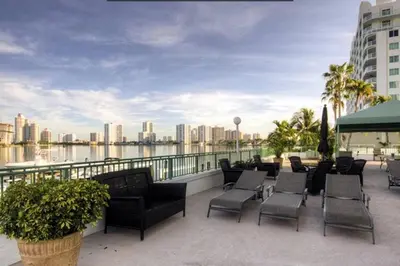 a balcony with chairs and a view of a city at Le Montcalm 601 STR-01927 in Sunny Isles Beach