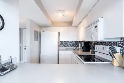 a kitchen with white cabinets and a white refrigerator at Le Montcalm 804 STR-01923 in Sunny Isles Beach