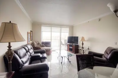 a living room with leather couches and a table at Le Marina Bay PH5 STR-01500 in Sunny Isles Beach
