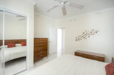 a bedroom with a mirror and a bed and a ceiling fan at Le Marina Bay PH5 STR-01500 in Sunny Isles Beach