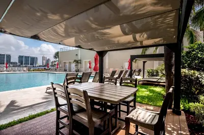 a table and chairs on a patio next to a pool at Le Marina Bay PH5 STR-01500 in Sunny Isles Beach