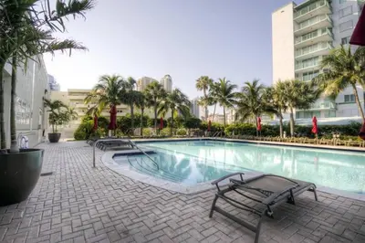 a large swimming pool with palm trees and buildings at Le Marina Bay 810 STR-01434 in Sunny Isles Beach