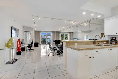 an open kitchen with a counter and chairs in a room at Les Pelicans #316 STR-02743 in Sunny Isles Beach