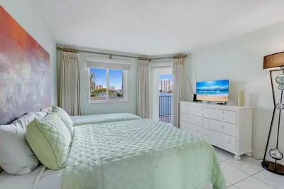 a bedroom with a bed and a dresser and a window at Les Pelicans #316 STR-02743 in Sunny Isles Beach
