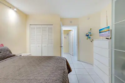 a bedroom with a bed and a refrigerator at Les Pelicans #316 STR-02743 in Sunny Isles Beach