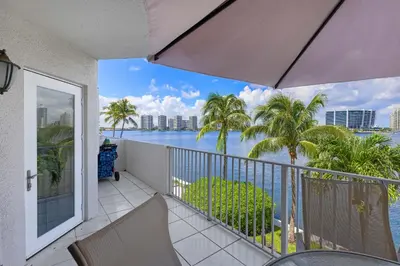 a balcony with a view of the ocean and palm trees at Les Pelicans #316 STR-02743 in Sunny Isles Beach