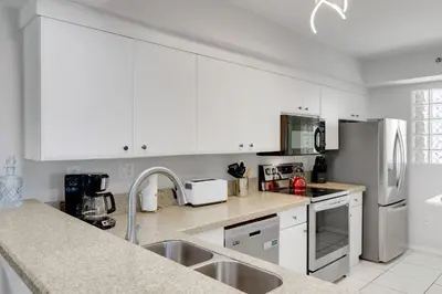 a kitchen with white cabinets and white appliances at Les Pelicans #316 STR-02743 in Sunny Isles Beach