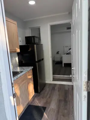 a kitchen with a refrigerator and a door to a living room at Modern private efficiency Miami Gardens in Miami Gardens