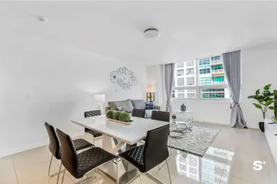 a dining room and living room with a table and chairs at Modern 2-BD Condo in Midtown Miami Pool & Gym in Miami
