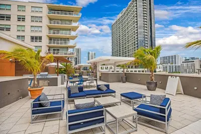 a patio with blue chairs and palm trees and a building at Modern 2-BD Condo in Midtown Miami Pool & Gym in Miami