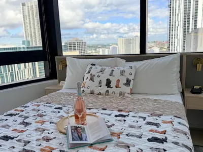 a bedroom with a bed with a book and a magazine at District 225 in Miami