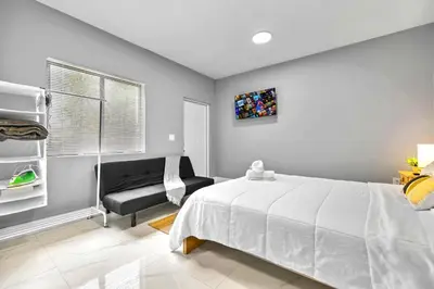 a bedroom with a white bed and a chair at Comfy Studio W Essentials Near Airport in Miami