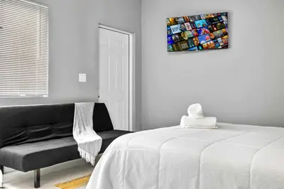 a bedroom with a bed and a chair and a painting at Comfy Studio W Essentials Near Airport in Miami