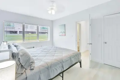 a white bedroom with a bed and a window at Beachside Escape with King Bed plus 2 Queens Miami in Miami Beach