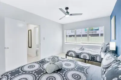 a bedroom with two beds and a window at Bright 1BR Miami Beach Apt with 3 Queens & Smart TV in Miami Beach