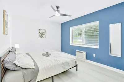 a bedroom with blue walls and a bed with a ceiling fan at 1BR Miami Beach Apt with King plus 2 Queens & Smart TV in Miami Beach