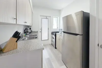 a kitchen with a refrigerator and a sink at 1BR Miami Beach Apt with King plus 2 Queens & Smart TV in Miami Beach