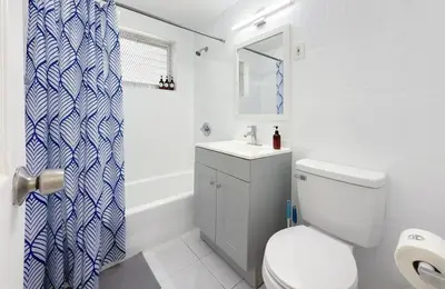 a bathroom with a toilet and a sink and a shower at 1BR Miami Beach Apt with King plus 2 Queens & Smart TV in Miami Beach