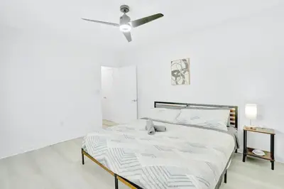 a white bedroom with a bed with a ceiling fan at 1BR Miami Beach Apt with King plus 2 Queens & Smart TV in Miami Beach