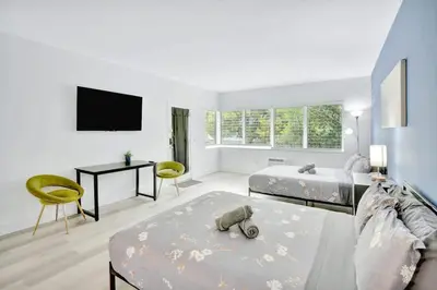 a living room with two beds and a tv at 1BR Miami Beach Apt with King plus 2 Queens & Workspace in Miami Beach