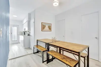 a dining room with a wooden table and benches at 1BR Miami Beach Apt with King plus 2 Queens & Workspace in Miami Beach