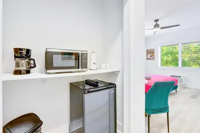 a kitchen with a microwave and a table and chairs at Modern Miami Beach Studio with King Bed in Miami Beach