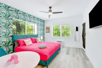 a bedroom with a pink bed and a table at Modern Miami Beach Studio with King Bed in Miami Beach
